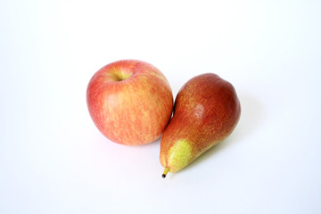 Ripe red apple and green pear lying on white background