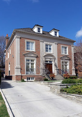 Classical style house with dormers and long driveway