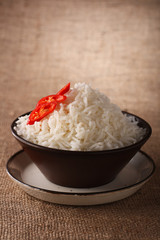 rice bowl with fresh chillies on brown rustic background,