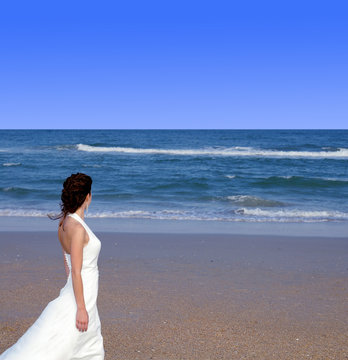 Beautiful woman standing on a beach, looking to the horizon
