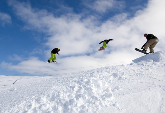 Snowboarders Jumping