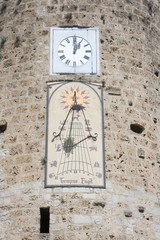 Vieux cadran solaire sous une pendule moderne dans la ville d'Anduze