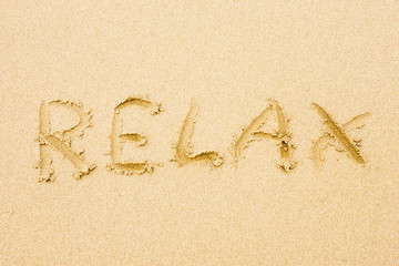 Sandy beach with word Relax written on sand