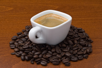 Espresso coffee cup with coffee beans on table