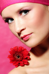 Fototapeta premium beauty portrait of a young woman in pink with a gerbera