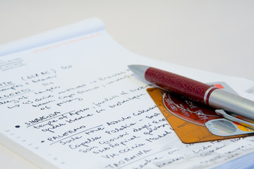 a close-up of a notebook, credit card and a pen