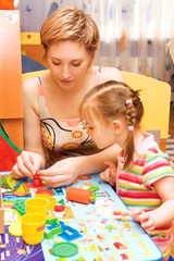 mom and daughter playing with plasticine