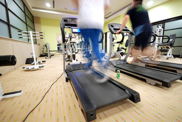 Fototapeta na wymiar Man running on treadmill in gym