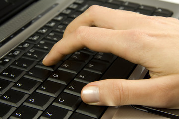 Human hand on laptop keyboard