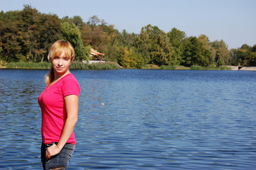 Girl on blue water lake in the forest