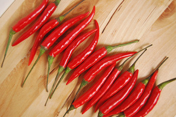 Red chili peppers on wooden board