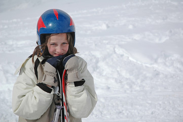 Fototapeta na wymiar girl in snow holding skis