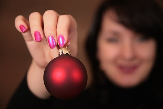 woman with christmas ball in hand