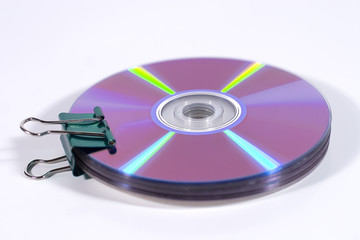 Compact discs in a binder clip (white background)