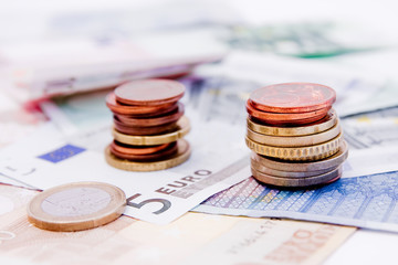 Euro banknotes with various coins