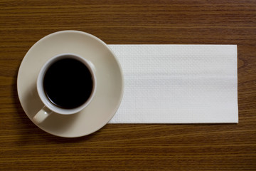 Obraz na płótnie Canvas A cup of coffee with napkin on a table