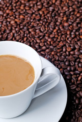 Coffee in a white cup with coffee beans