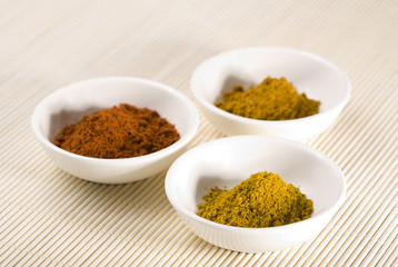 curry, cayenne pepper and turmeric in white bowls