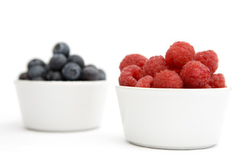 A bowl of blueberries and raspberries (focus on raspberries)