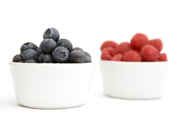 A bowl of blueberries and raspberries (focus on blueberries)