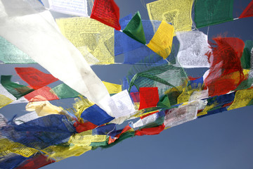 praying flags floating in the wind on blue sky