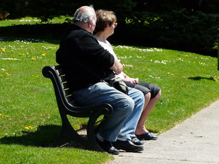 couple de séniors assis sur un banc public