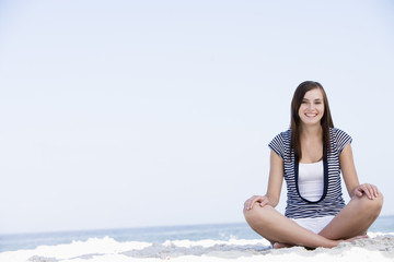 Fototapeta na wymiar Young woman sitting on beach