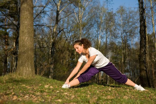 Sporty girl exercising on forest