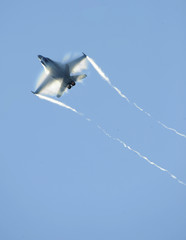An airforce jet fighter streaks through the sky.