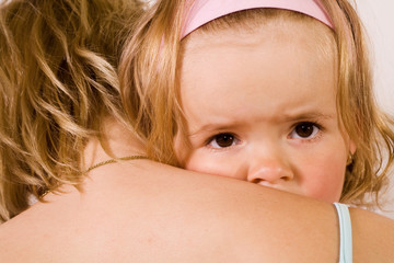 Little girl cuddling with her mother - closeup