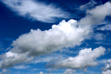 Big fluffy clouds against deep bright blue sky.