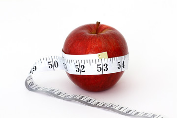 A red apple with a red measuring tape around it.