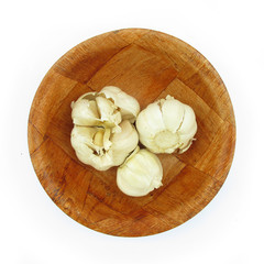 Garlick in wooden dish isolated on white
