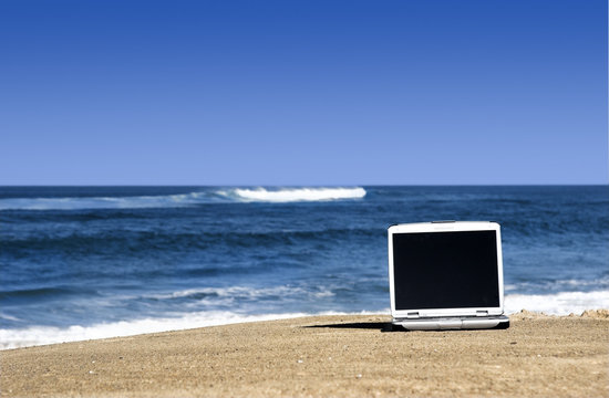 Laptop on the beach © ikostudio