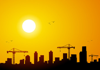 Fototapeta na wymiar City at sunset with cranes