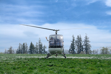 Small passenger helicopter hovering on blue sky