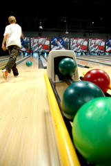 A bowling alley with balls in the rack
