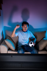 Naklejka premium Man watching live football game on TV