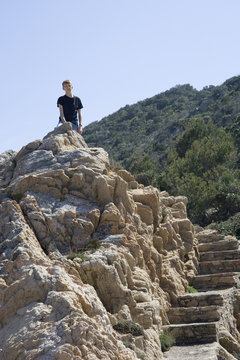 teen sitting on top of the rocks