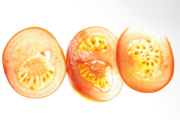backlit tomato slice on white background