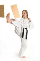Black belt female martial artist doing board break.