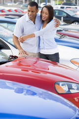 Young couple looking at new cars - obrazy, fototapety, plakaty