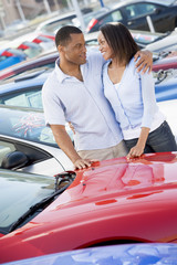 Young couple looking at new cars © Monkey Business