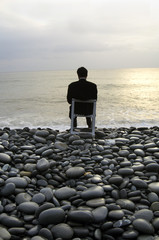Fototapeta na wymiar Silhouette of businessman meditating on the beach