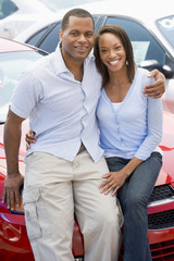 Young couple looking at new cars
