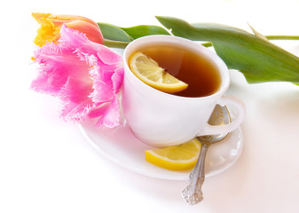 A cup of tea with lemon and a flower