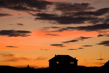 Arctic dawn: silhouette of a remote house
