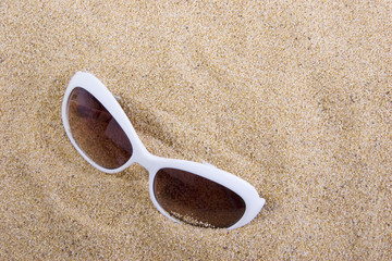Fototapeta na wymiar Sunglasses in the sand