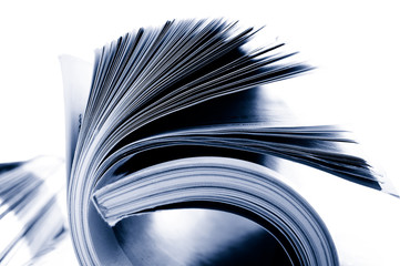 Closeup of rolled magazine pages, on white