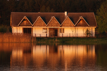 Old abandoned building reflecting in the lake at sunset